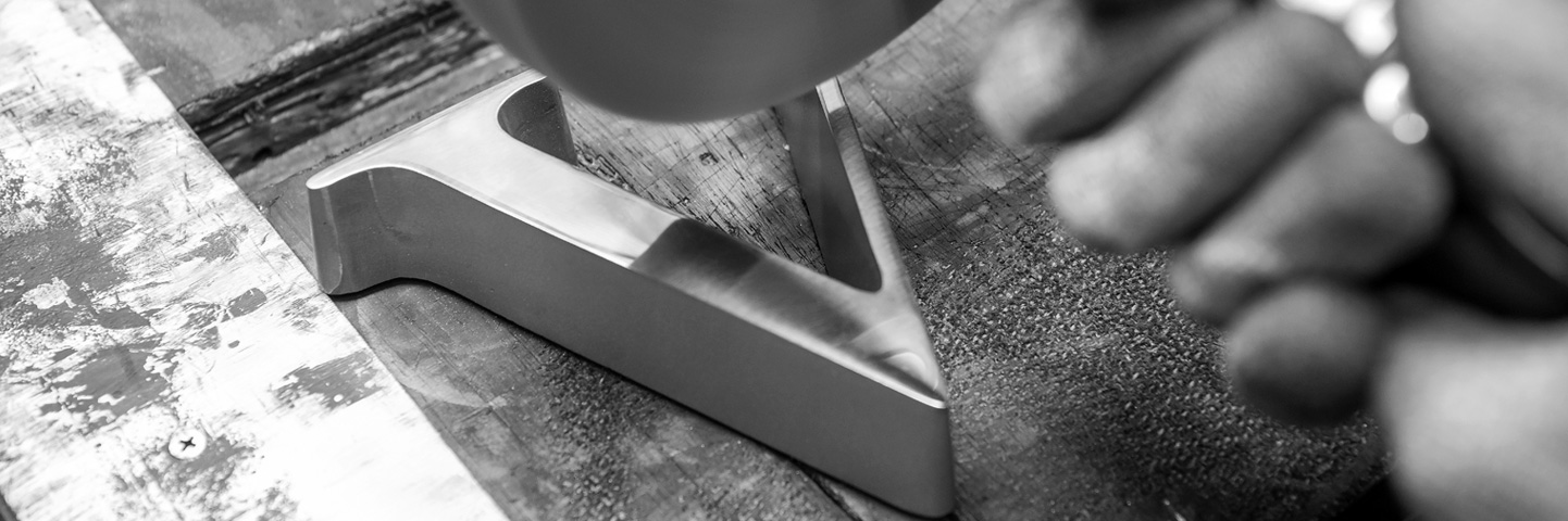 metal worker polishing the letter v